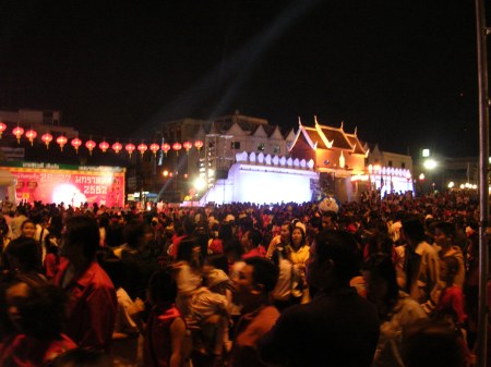 Lots and lots of people.  This was just one of several sections of the celebration.  On the left, people are watching a variety show including tradition clothing fashion show and comedic lip-synching.  Lit-up on the right is a portion of the old city wall, restored.